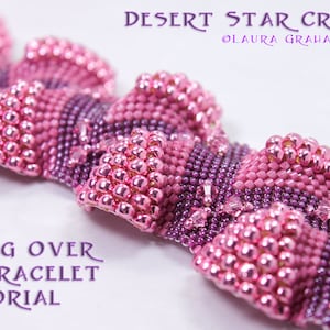 May include: A close-up of a pink and purple beaded bracelet with a scalloped edge. The bracelet is made with small, round beads and has a shiny finish. The text "Bubbling Over Pinks Bracelet Tutorial" is visible in the image.