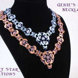 Op de afbeelding: Drie kralenkettingen op een zwart manekin. De bovenste ketting is blauw, de middelste ketting is lichtblauw en de onderste ketting is koperkleurig en roze. Alle kettingen hebben een bloemmotief. De tekst "GENIE'S LAMP NECKLACE" staat bovenaan de afbeelding en de tekst "DESERT STAR CREATIONS" staat onderaan de afbeelding.