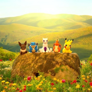 May include: A set of five small plastic character figurines including a brown Eevee, a blue Blastoise, a white Mewtwo, an orange Dragonite, and a yellow Pikachu, all standing in a row on top of a large, weathered, mossy brown rock.