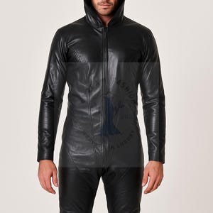 May include: Black leather hooded jumpsuit with a front zipper closure. The one-piece garment features long sleeves and a tailored fit. The model is wearing the jumpsuit. The jumpsuit is made of leather.