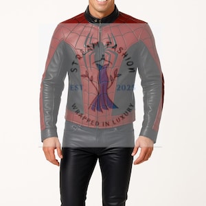 Op de afbeelding: Een rode, grijze en zwarte leren jas met een spinnenwebontwerp op de borst en schouders. De jas heeft een ritssluiting en een opstaande kraag. De tekst "STAR FASHION 2025 WRAPPED IN LUXURY" is zichtbaar op de borst.