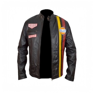 May include: Black leather jacket with a stand-up collar and a zipper closure. The jacket features patches with the "HEUER" and "Firestone" logos, and a vertical stripe in yellow, red, and orange with the "Gulf" logo.