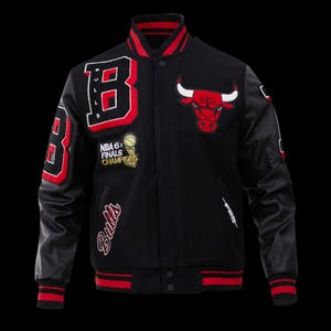 Pode incluir: Casaco universitário preto com detalhes em vermelho e branco. Apresenta o logotipo do Chicago Bulls, a inscrição "Bulls" e o emblema "NBA 6x Finals Champions". Inclui mangas de couro e gola e punhos listrados.