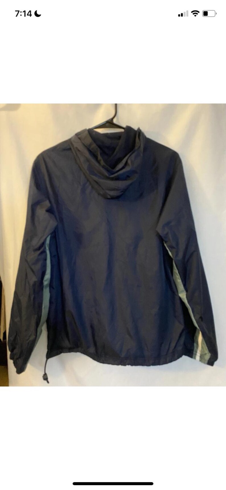 May include: Navy blue hooded jacket with a drawstring hem and a light green stripe detail on the sleeves. The jacket is hanging on a black hanger against a white background.