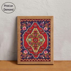 May include: A framed print featuring a colorful, patterned design reminiscent of a traditional rug. The print has a central red diamond shape with floral and geometric elements in gold, green, and pink, set against a dark blue background. The frame is made of light-colored wood. The text "Print on Demand" is in the upper left corner.