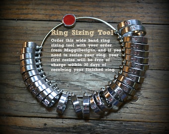 May include: A silver ring sizing tool with a red dot on the top. The tool has a series of rings with numbers from 5 to 11, and the text "Ring Sizing Tool" is printed on the tool.