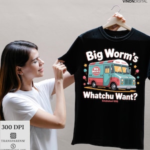 Pode incluir: Camiseta preta com um design colorido de um caminhão de sorvete e o texto "Big Worm's Whatchu Want? Established 1995." O design inclui casquinhas de sorvete e estrelas. A camiseta está sendo segurada por uma pessoa.
