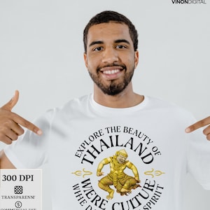 Puede incluir: Camiseta blanca con un diseño circular. El texto dice "EXPLORE THE BEAUTY OF THAILAND" y "WHERE CULTURE DANCES WITH SPIRIT". El diseño incluye una ilustración dorada de un bailarín tailandés.
