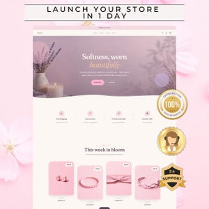 May include: A website template design featuring a soft lavender and pink color palette. The header displays the text 'LAUNCH YOUR STORE IN 1 DAY' and 'Softness, worn beautifully'. The page includes product listings, icons for shipping, and three gold circular badges.