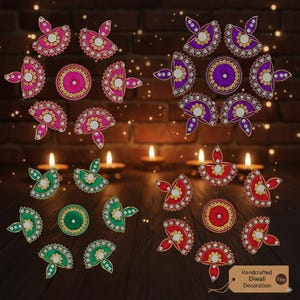 Könnte beinhalten: Handgefertigte Diwali-Dekorationen in Pink, Lila, Grün und Rot. Die Designs umfassen kreisförmige und blütenblattförmige Ornamente mit aufwendigen Details. Das Bild zeigt auch brennende Kerzen und ein Etikett mit der Aufschrift "Handcrafted Diwali Decoration Etsy".
