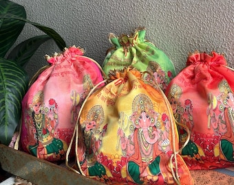 May include: A collection of drawstring bags in various colors, including pink, green, and orange. Each bag features a detailed illustration of a deity with gold accents and text. The bags are arranged on a decorative tray.