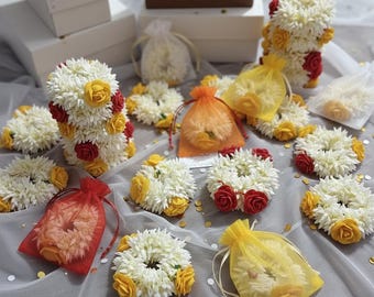 Gajra floral roja y amarilla a granel y pulsera en potli transparente - 10/50/100 piezas. Recuerdos de boda al por mayor para invitados de Haldi, Mehendi y Sangeet.