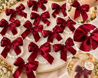 May include: A collection of circular pearl bracelets featuring deep red satin bows and a central clear rhinestone accent. The bracelets are displayed on a round tray and individually packaged in sheer organza bags with a Thank You tag.