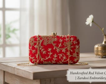 Puede incluir: Bolso de mano rectangular de terciopelo rojo con bordado Zardosi dorado. El bolso tiene una correa de cadena dorada y un cierre dorado. El texto de la imagen dice "Handcrafted Red Velvet Clutch | Zardosi Embroidery".