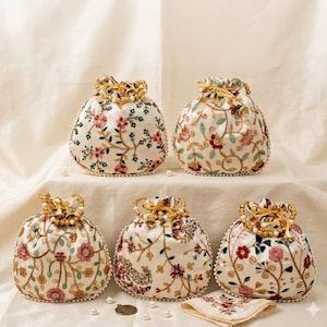 May include: Five cream-colored drawstring bags with floral embroidery in pink, red, and green. Each bag has a beaded trim and a gold-colored drawstring closure. A matching embroidered handkerchief is also present.