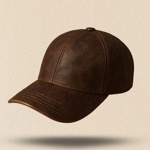 May include: A brown leather baseball cap with a curved brim. The cap has a classic six-panel design with stitching details and a button on top. The hat appears to be made of a distressed leather material.