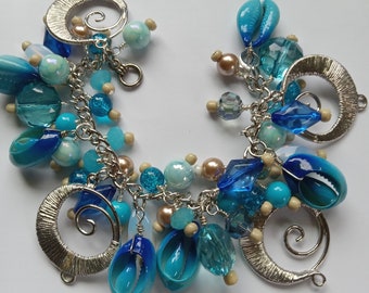 Sea theme charm bracelet in shades of blue with blue cowry seashells, cha cha bracelet in ocean colors