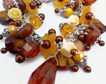 Cha cha bracelet in autumn colors, brown, buttery yellow, and cream with floral charms, beaded charm bracelet
