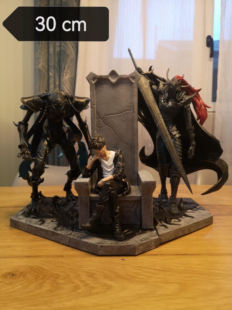 May include: A detailed figurine set, approximately 11.8 inches (30 cm) wide, featuring a central throne with a seated figure. Flanking the throne are two imposing, dark-colored figures, one with a large sword. The set is on a gray, geometric base.