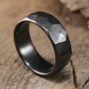 May include: A black hammered metal ring with a matte finish.