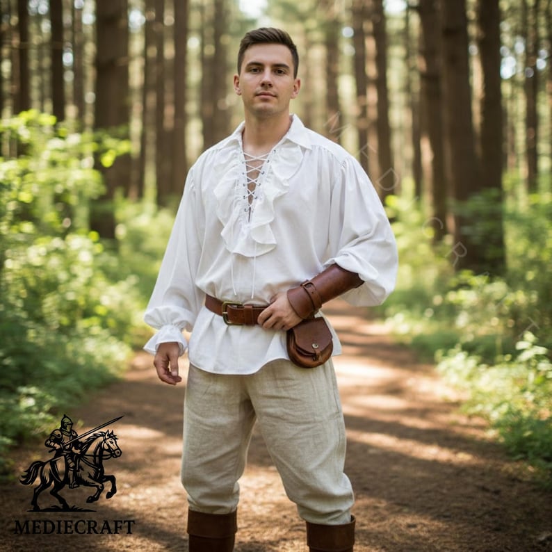 Man wearing white medieval ruffle shirt with lace up front, renaissance fair pirate style cotton tunic in forest setting.