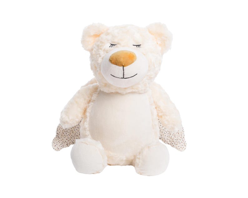 A white stuffed teddy bear with a smiling expression and wings on its back.