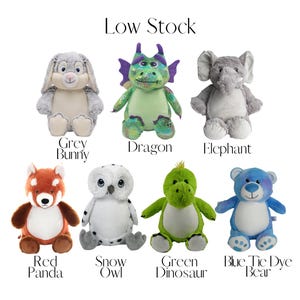 a collection of stuffed animals, including a panda, rabbit, dragon, elephant, panda, owl, snow owl, green dinosaur, and blue tie dye bear.