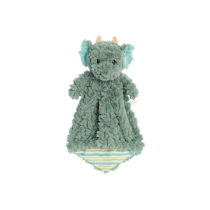 a green stuffed animal hanging on a white wall