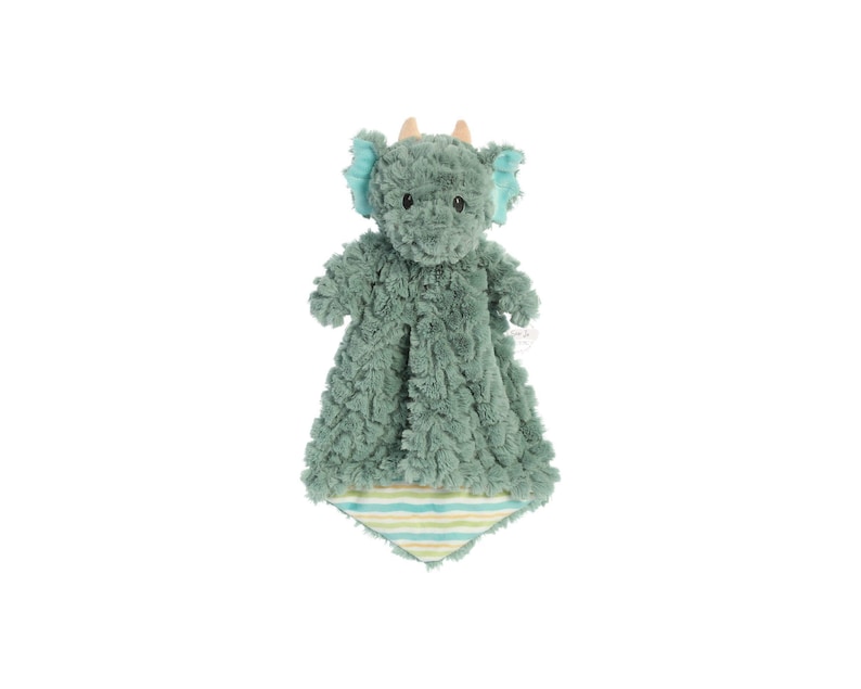 a green stuffed animal hanging on a white wall