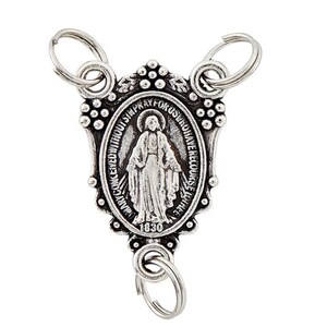 May include: A silver-coloured religious medal with three key rings. The oval-shaped medal features an image of a religious figure and the text "MARY COKCEIVED WITHOUT SIN PRAY FOR US WHO HAVE RECOURSE TO THEE" and the year "1830".