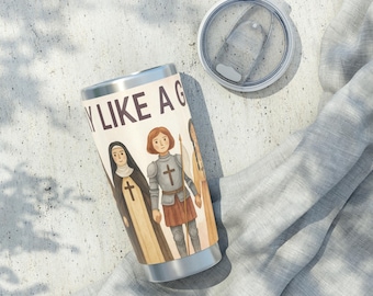 May include: Stainless steel tumbler with a lid, featuring an illustration of three figures and the text "Y LIKE A G". The figures include a nun, a woman in armor, and another figure. The tumbler is cylindrical and has a silver rim.