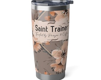 May include: A stainless steel tumbler with a floral pattern and the text "Saint Trainer Fueled by Prayer & Coffee".