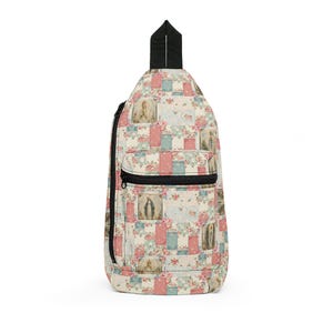 May include: A sling backpack featuring a patchwork pattern of floral motifs in shades of pink, blue, and cream, interspersed with rectangular panels depicting religious figures. The bag includes a black zipper closure and a black top handle strap.
