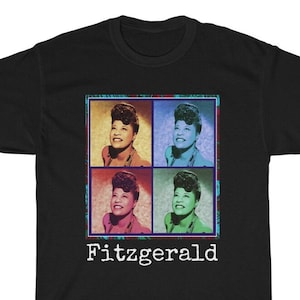 Puede incluir: Camiseta negra con una imagen colorida de Ella Fitzgerald en cuatro cuadrados. La imagen está rodeada por un borde decorativo. El texto "Fitzgerald" está impreso debajo de la imagen.