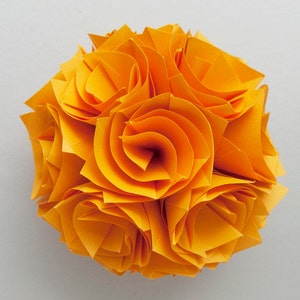 May include: A bright yellow origami flower with multiple layers of petals, creating a spherical shape.