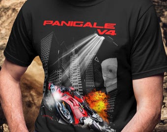 Puede incluir: Una camiseta negra de manga corta con un estampado gráfico de una motocicleta roja inclinada en una curva. El diseño incluye el texto PANIGALE V4 en rojo, un fondo de ciudad con un foco brillante y una explosión de llamas naranjas y amarillas.
