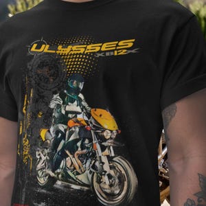 Pode incluir: Camiseta preta com um gráfico de motocicleta e o texto amarelo "ULYSSES XB12X". O gráfico mostra um piloto em uma motocicleta amarela e preta. A camiseta tem gola redonda.