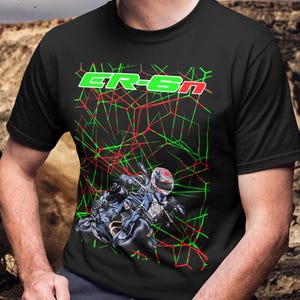 May include: Black t-shirt featuring a motorcycle graphic with a rider in a helmet. The shirt has the text "GR-6N" in green and red, with a geometric design overlay.
