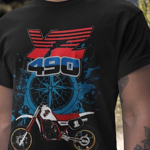 May include: Black t-shirt featuring a graphic of a red and white motorcycle with the number 1. The design includes the text "YZ 490" in red, white, and blue, along with a blue compass design.
