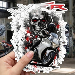 Puede incluir: Una pegatina con una moto blanca y un piloto, sobre un fondo de calavera con ojos rojos y formas geométricas. La palabra "VFR" se muestra en blanco y rojo.