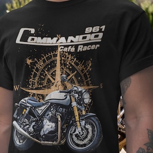 May include: Black t-shirt with a motorcycle graphic. The design includes the text "Commando 961 Café Racer" and a compass rose. The motorcycle illustration is in shades of grey, gold, and black, evoking a vintage aesthetic.