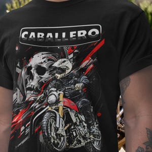 Puede incluir: Camiseta negra con un diseño de motocicleta, un motorista, una calavera y la palabra "CABALLERO" en un marco blanco. El diseño incorpora acentos rojos y blancos, creando una estética dinámica y atrevida.
