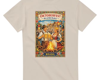 May include: Beige t-shirt featuring a colorful Oktoberfest-themed graphic. The design includes a couple holding beer steins, a bonfire, and the text "OKTOBERFEST - BLUMENAU - BRASIL". The graphic is framed with decorative borders.