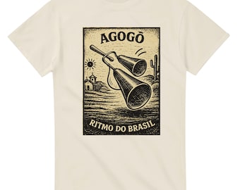 May include: Cream-colored t-shirt featuring a black and white graphic of an agogô bell instrument with the text "AGOGÔ" and "RITMO DO BRASIL". The design includes a sun, church, and cactus.