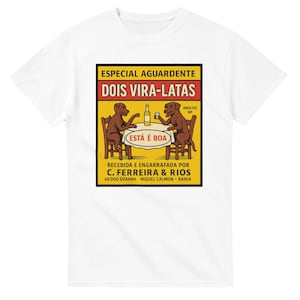 Peut inclure: T-shirt blanc avec un graphisme de style vintage. Le graphisme est un rectangle jaune et noir avec le texte "ESPECIAL AGUARDENTE DOIS VIRA-LATAS" et une illustration de deux chiens à une table. Le texte "ESTÁ É BOA" est également présent.