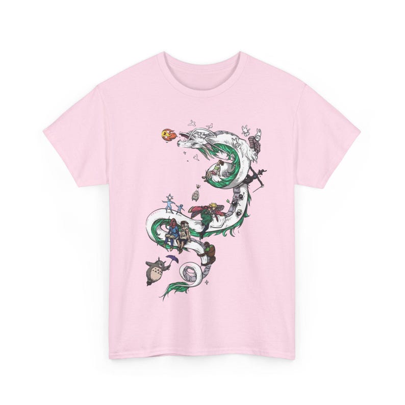 May include: A light pink t-shirt featuring a detailed illustration of a white and green dragon with various animated characters. The design includes characters from popular animated films, creating a whimsical and artistic aesthetic.