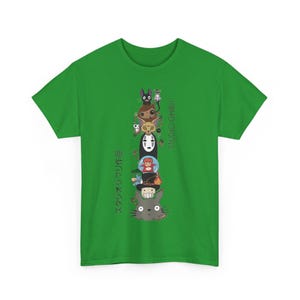 Puede incluir: Camiseta verde con un dise&ntilde;o vertical de personajes de dibujos animados de Studio Ghibli, incluyendo a Totoro y Sin Cara. La camiseta tambi&eacute;n presenta el texto "STUDIO GHIBLI" y texto japon&eacute;s. Un dise&ntilde;o vibrante y colorido.