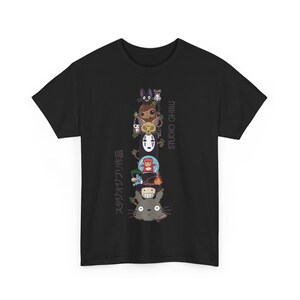 Puede incluir: Camiseta negra con un dise&ntilde;o vertical de personajes de Studio Ghibli. El dise&ntilde;o incluye personajes como Totoro y Sin Rostro. El texto "STUDIO GHIBLI" y texto japon&eacute;s tambi&eacute;n est&aacute;n presentes.