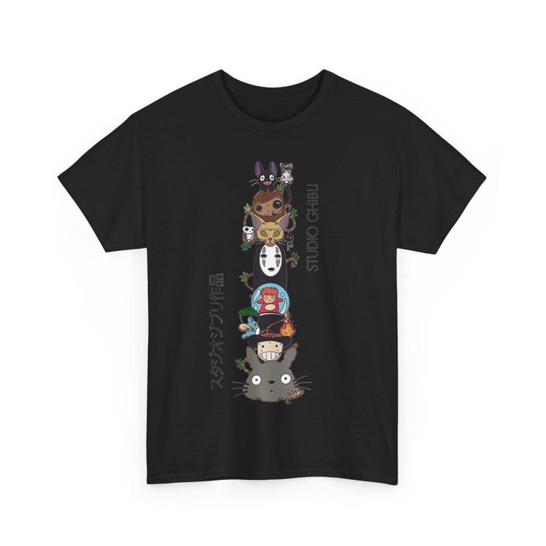 Puede incluir: Camiseta negra con un dise&ntilde;o vertical de personajes de Studio Ghibli. El dise&ntilde;o incluye personajes como Totoro y Sin Rostro. El texto "STUDIO GHIBLI" y texto japon&eacute;s tambi&eacute;n est&aacute;n presentes.