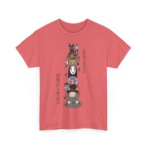 Puede incluir: Camiseta de color coral con un dise&ntilde;o apilado de personajes de Studio Ghibli. El dise&ntilde;o incluye personajes de varias pel&iacute;culas de animaci&oacute;n, con texto japon&eacute;s a la izquierda y "STUDIO GHIBLI" en ingl&eacute;s a la derecha.